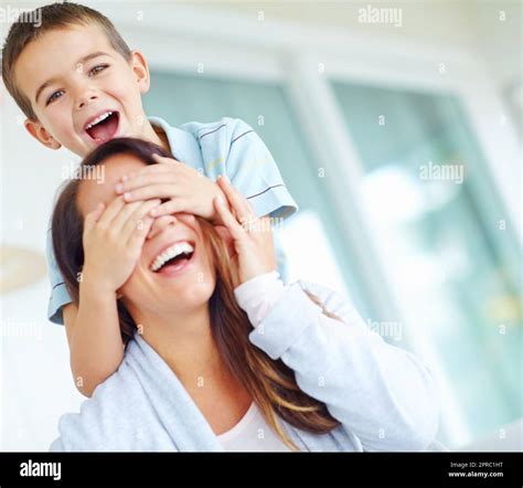 Playing games with mom. A little boy putting his hands over his mothers ...