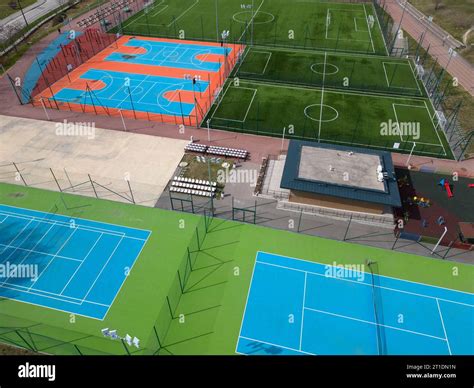 aerial view of a green football field, colorful basketball courts, and ...