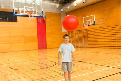 Boy Of Eleven Playing With Red Fitness Ball School Gymnasium Stock Photo - Download Image Now ...