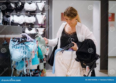 Woman Choosing Light Green Swimming Suit at Clothes Store and Looking ...
