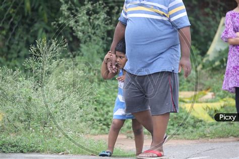 Image of Indian Little girl walking with a Fat Man-ZE444952-Picxy