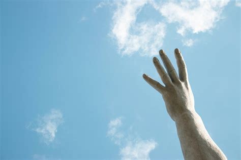 A statue of a hand reaching up into the sky photo – Free Hand Image on ...