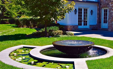 Custom water feature with a raised stone bowl, with a lower basin and ...