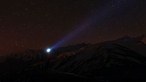 Download wallpaper 1600x900 man, flashlight, beam, light, night, starry ...