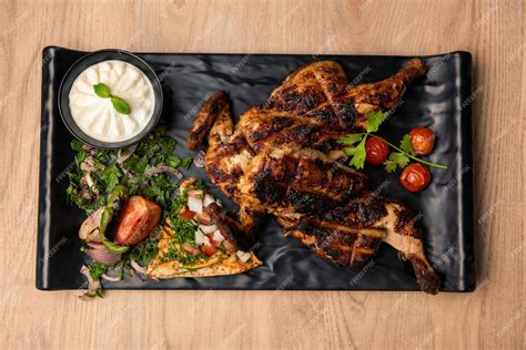 Premium Photo | Full grilled chicken with mayo dip and salad served in ...