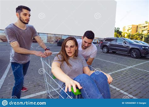 Group of Carefree Young Friends with Shopping Cart Riding on Par Stock ...