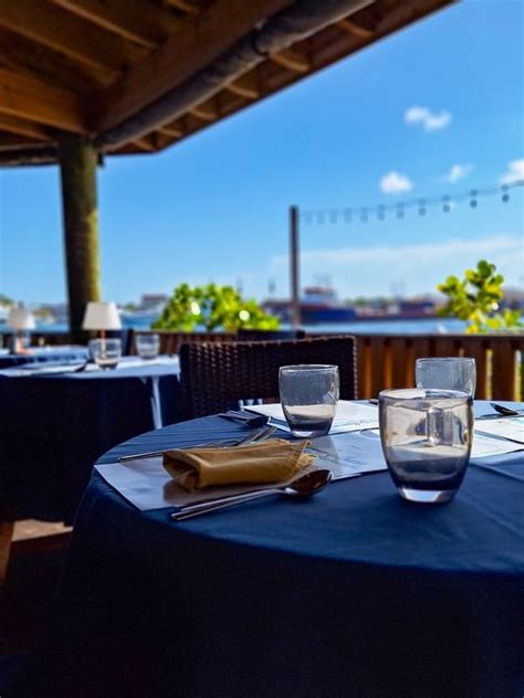 Dining tables under a wooden pavilion by a scenic waterfront in ...