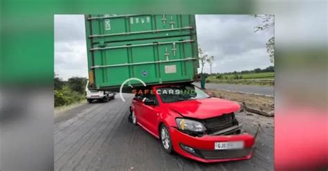 Truck carrying container falls on to the roof of a Volkswagen Polo ...