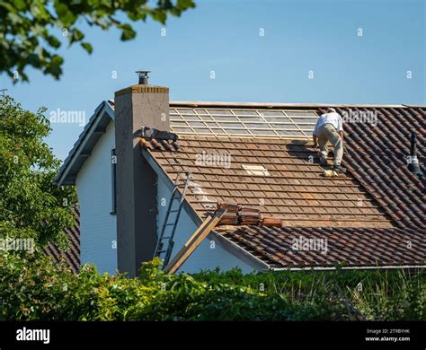Handyman repairing the roof, roofing and roof tiles replacement Stock ...
