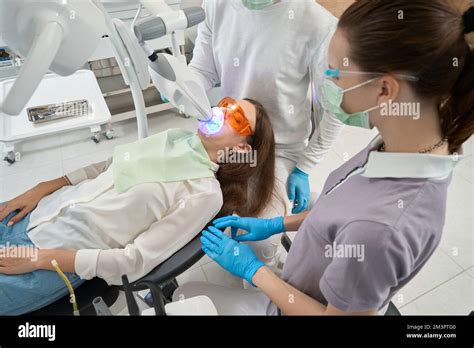 Dentist carrying out dental procedure on male patient, close-up