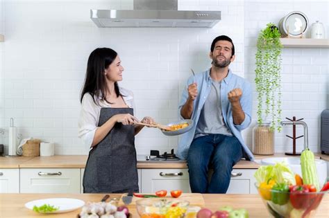 Романтическая пара на кухне Мужчина пробует еду с хорошим вкусом ...