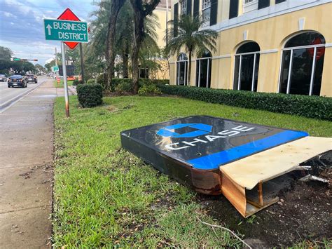 Heavy winds from storm knock down Chase Bank sign, topple tree onto ...
