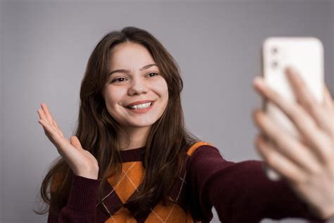 Jovem mulher sorridente filmando-se ao telefone | Foto Grátis