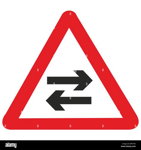 uk road sign arrows two way traffic crossing ahead Stock Photo - Alamy
