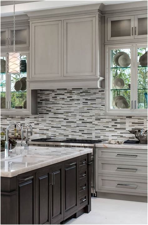 a kitchen with gray cabinets and marble counter tops