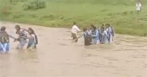 Video: Students forced to cross flooded river on foot to reach school ...