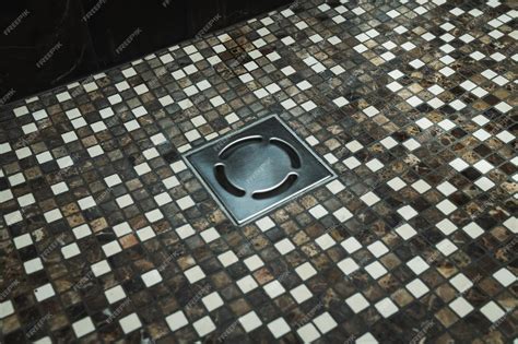 Premium Photo | Floor drain with small tiles in bathroom shower