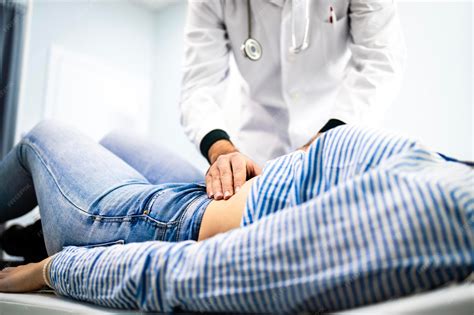 Premium Photo | Doctor gastroenterologist palpates patient stomach abdominal examination and ...