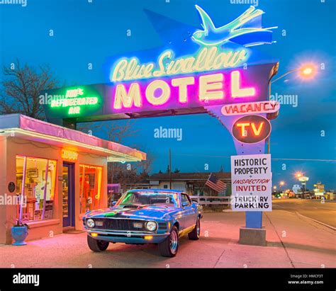 Twilight at the historic Blue Swallow motel on Route 66. A 1970 Ford Mustang classic car is ...