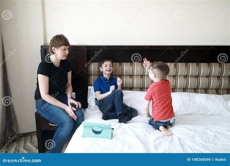 Mother with sons on bed stock photo. Image of people - 148268590