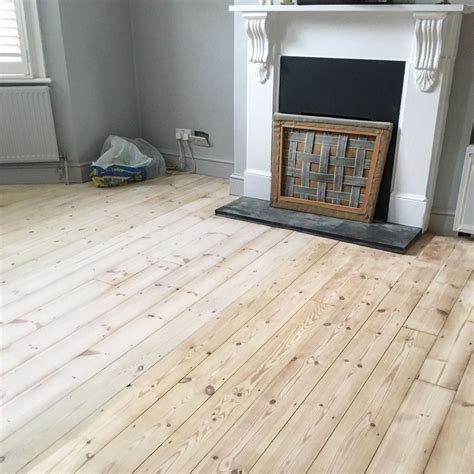 Pine wooden floorboards half treated with Finney's white wood dye ...