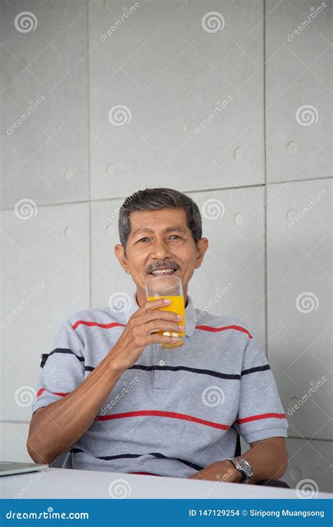 Old Man Drink Orange Juice for Healthy in His Work Room Stock Photo ...