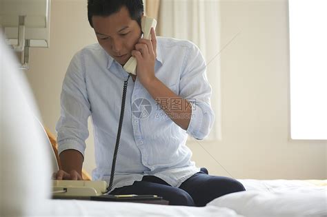 商人前台床男子在酒店打电话高清图片下载-正版图片502137174-摄图网