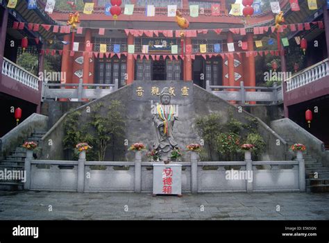 Photo of an elaborate Chinese temple with hedges in front.