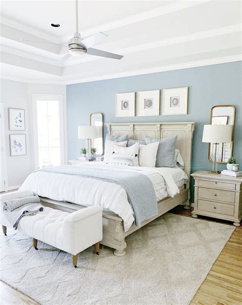 a bedroom with blue walls, white furniture and a large bed in the ...