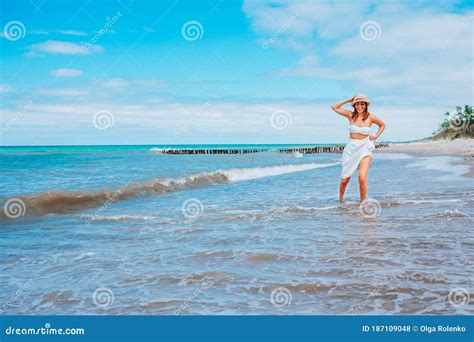 Beautiful Woman Wearing Straw Hat, White Swimsuit and Skirt Walking ...