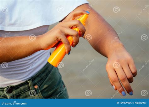 Hands of a Dark-skinned Woman Close Up Holding a Bottle of Sunscreen Spray Applying Spf Cream on ...