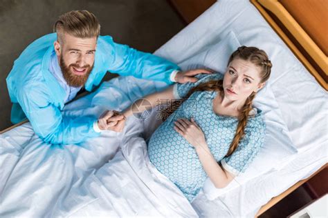 孕妇与丈夫手牵在医院看着相机的俯视图高清图片下载-正版图片502709662-摄图网