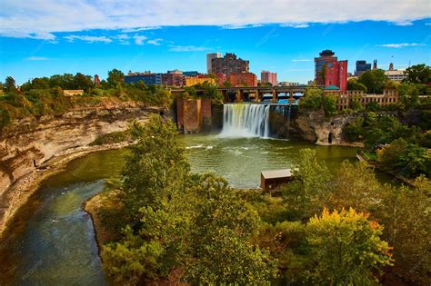 Premium Photo | Rochester skyline along river and cliffs with waterfall ...