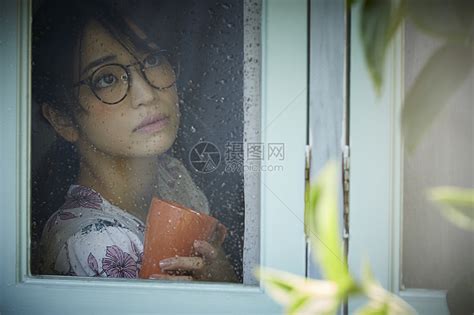 透过窗户看下雨的年轻女人高清图片下载-正版图片502122058-摄图网