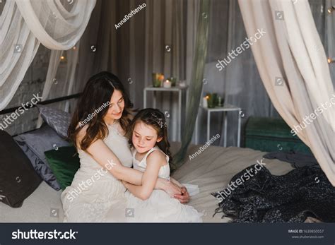 Mother and daughter cuddling on a bed in a kids room