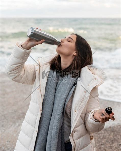 从瓶子里喝水的女人海滩美女服装高清摄影大图-千库网