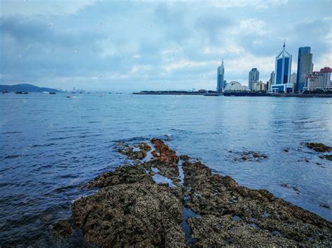 青岛海边礁石天际线白天阴天大海礁石大海风光摄影图配图高清摄影大图-千库网