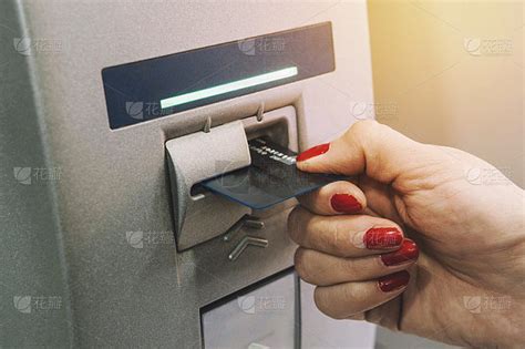 女子将信用卡插入自动取款机。那女孩从自动提款机拿钱。卡从终端出来。