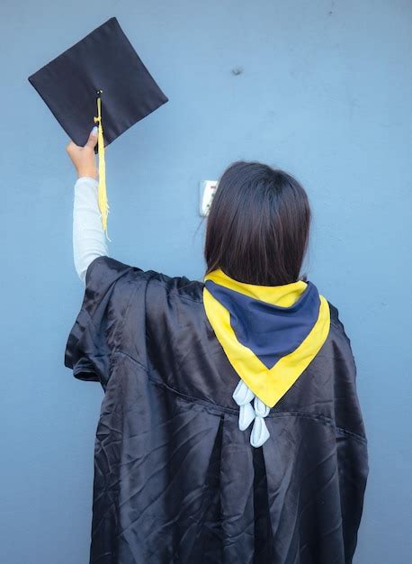 A woman is holding a graduation cap | Premium Photo