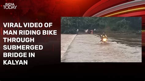 Video: Man risks life, rides bike through submerged bridge in ...