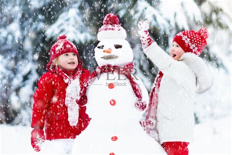孩子们建造雪人。孩子们在雪。冬天的乐趣。照片摄影图片_ID:311242418-Veer图库