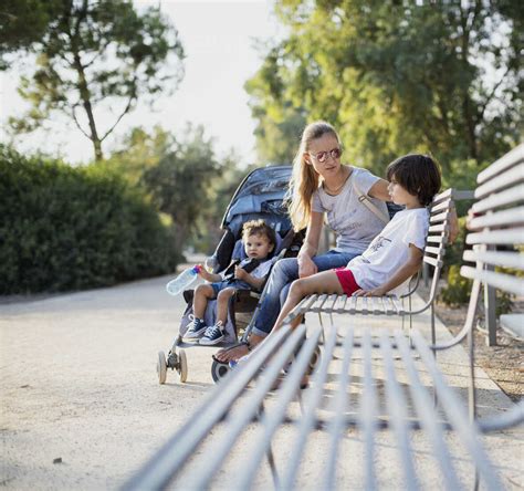 Adult daughter talking to her senior parents on a bench in a park