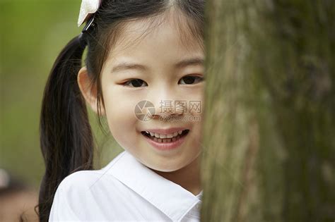 躲在树后的小女孩高清图片下载-正版图片502097162-摄图网