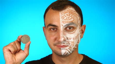 Man with painted face is looking at camera and showing coin with the ...