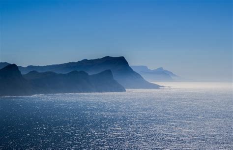 Aerial breathtaking view of the sea with hills on the under a blue sky ...