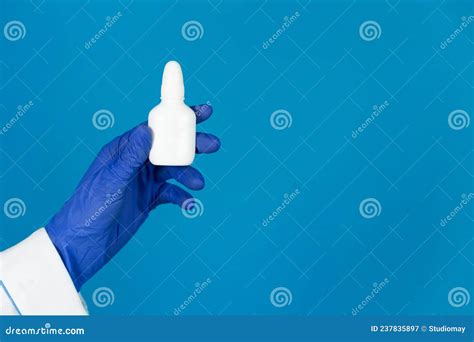 Doctors Hand in a Glove Holds a Nasal Spray for Runny Nose on a Blue Background with Copy Space ...