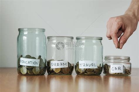 分配现金储蓄概念手把硬币放在玻璃钱箱高清图片下载-正版图片503569144-摄图网
