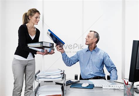 A manager handing a folder to an employee.