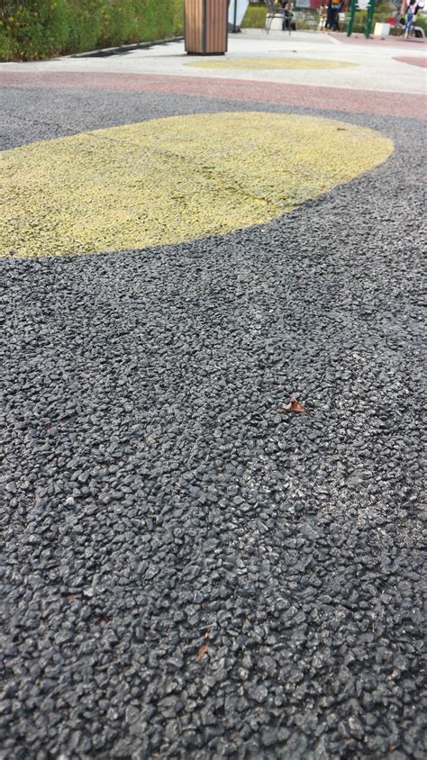 Black asphalt pebble stone flooring with epoxy resin in city park ...