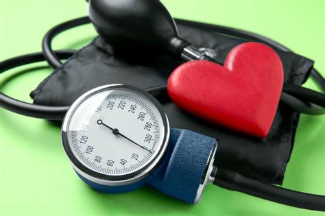 Blood pressure measuring device and heart figure on green background ...
